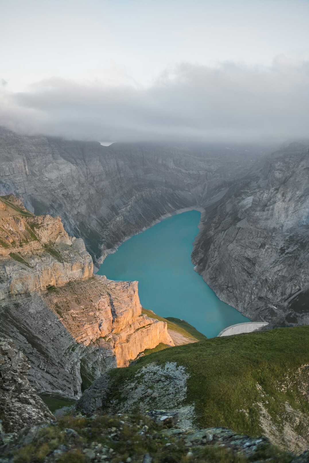 Turquoise lake surrounded by mountains at sunset in Switzerland