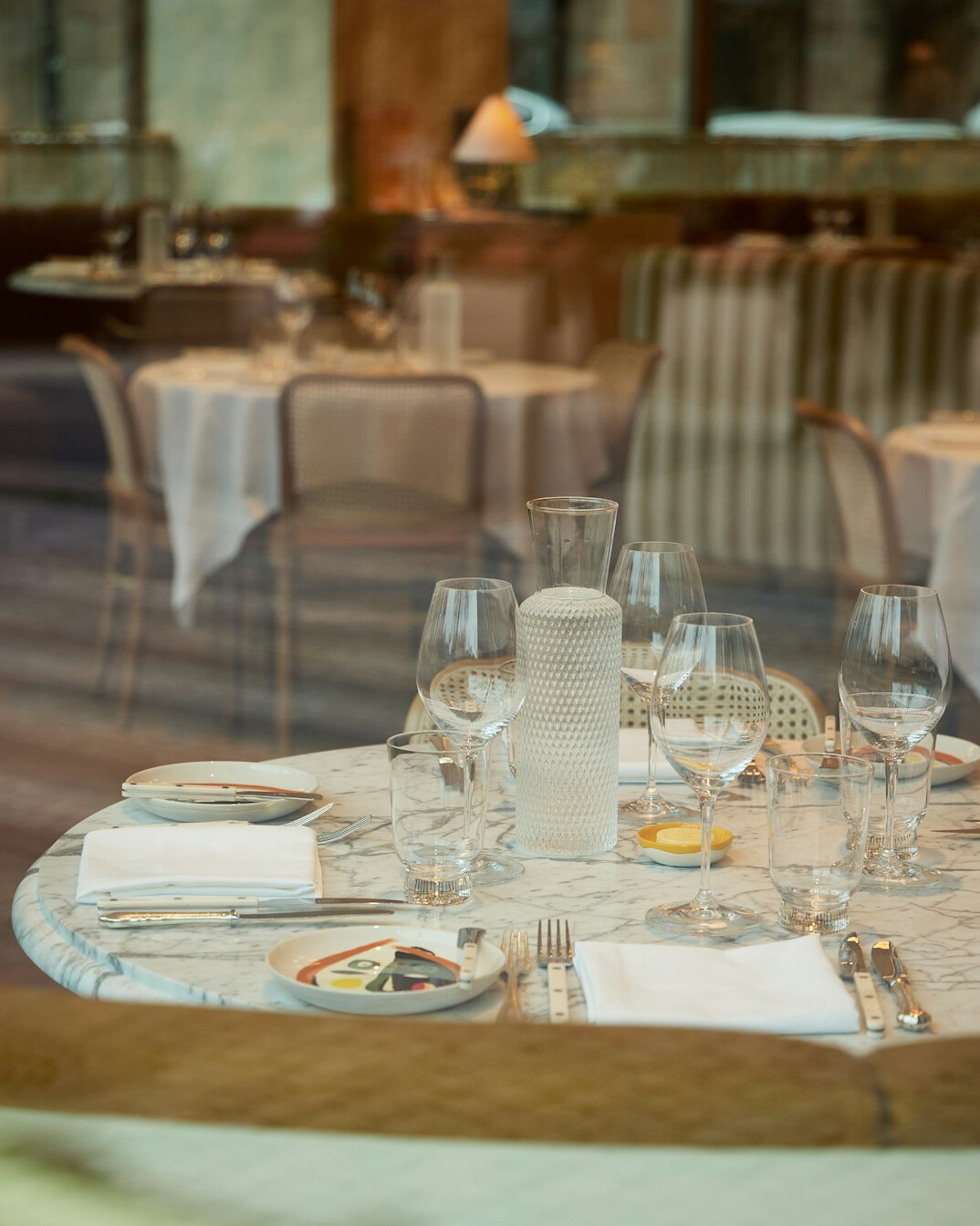 Elegant restaurant table set with fine dining dishes and candles
